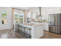 Bright kitchen with stainless steel appliances, a large island, and hardwood flooring at 318 Archar St, Summerville, SC 29486