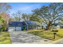 Single-story house with solar panels, a driveway, and a lush green lawn in a suburban setting at 32 Monte Sano Dr, Hanahan, SC 29410