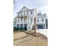 Elegant two-story white home with a covered front porch and a well-manicured lawn at 3853 Delinger Dr, Mount Pleasant, SC 29466