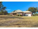 Lovely brick house with a metal roof, attached garage, and well-kept lawn, offering ample outdoor space at 732 Lindhaven Dr, Pineville, SC 29468