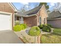 Inviting front entrance with brick pathway, manicured shrubs, and charming architectural details at 779 Hamlet Cir, Goose Creek, SC 29445