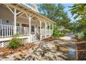 View of a charming home featuring a wrap-around porch and well-maintained landscaping at 94 Seaside Cottage Ln, Isle of Palms, SC 29451