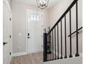 Bright foyer has stylish lighting and a staircase with black railings at 9402 Sweep Dr, Summerville, SC 29485