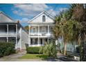 Two-story home with inviting double porches, manicured landscaping and palm tree at 318 Sumter St, Charleston, SC 29403