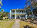 A beautiful two-story home with a large front porch, classic columns, and a well-manicured lawn at 1003 Wichman St, Walterboro, SC 29488