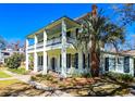 Charming home exterior with a two-story porch, white columns, a palm tree, and well-maintained landscaping at 1003 Wichman St, Walterboro, SC 29488