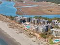 Aerial view featuring beachfront condos with a pool, set against an ocean and river backdrop at 1109 Diodia Ct, Kiawah Island, SC 29455