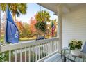 Cozy front porch featuring a glass table, patriotic flags, and views of the lawn at 112 Etiwan Park St, Charleston, SC 29492
