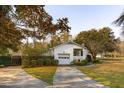 This white brick home includes a garage and covered porch. Lush landscaping and concrete driveway at 1245 Forestwood Dr, Charleston, SC 29407