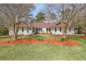 Charming brick home featuring landscaped yard with mature trees and colorful mulch at 1522 N Pinebark Ln, Charleston, SC 29407