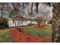 Charming brick home featuring landscaped yard with mature trees and colorful mulch at 1522 N Pinebark Ln, Charleston, SC 29407