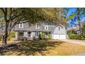 Captivating two-story home with dormer windows, a well-maintained lawn, and mature trees at 202 Hunt Club Dr, Summerville, SC 29485