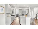 Open kitchen with stainless appliances, large island, and modern gray cabinets at 204 Belfort Pl, Summerville, SC 29486