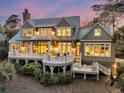 Beautiful rear exterior of home with covered decks, patios, and well-maintained landscaping at 212 Chinaberry Ln, Kiawah Island, SC 29455