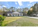 Beautiful single-story home featuring a well-manicured lawn, covered porch, and a long drive at 218 Mohican Cir, Summerville, SC 29483