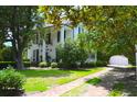 Charming home with a brick-lined drive and lush, green lawn, framed by mature trees at 219 Rigby St, Reevesville, SC 29471
