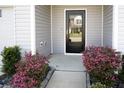 Inviting front entrance featuring a black door with glass, blooming shrubs, and a tidy walkway at 232 Buchanan Cir, Goose Creek, SC 29445