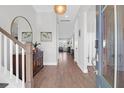 Bright foyer with wood floors, staircase, large mirror, and an open view to the living spaces at 2461 Lieutenant Dozier Dr, Johns Island, SC 29455