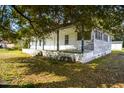 A charming single-story house with a front porch, surrounded by green grass and mature trees at 2604 Highway 78, Dorchester, SC 29437