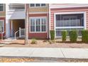 Charming condo exterior with red and yellow siding, white trim, and manicured landscaping at 300 Bucksley Ln # 104, Charleston, SC 29492