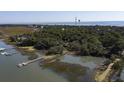 Aerial view of a waterfront community with private docks and lush green trees at 410 E Indian Ave, Folly Beach, SC 29439