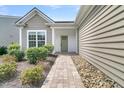 Inviting front entrance with a charming light green door and neatly landscaped walkway and garden at 418 Eastern Isle Ave, Summerville, SC 29486