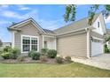 Beautiful home exterior features neutral siding, manicured bushes and green grass on a sunny day at 418 Eastern Isle Ave, Summerville, SC 29486