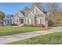 Well-maintained two-story home with lush lawn, a paved driveway, and inviting covered front porch at 4218 Club Course Dr, North Charleston, SC 29420
