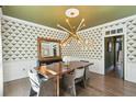 Chic dining room with designer wallpaper, modern chandelier, and a dark wood dining table at 442 Channel Creek Ct, Mount Pleasant, SC 29464