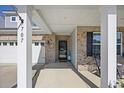 Inviting front porch with brick accents and rocking chairs, offering a cozy outdoor seating area at 707 Redbud Ln, Summerville, SC 29486
