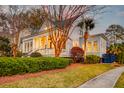 Beautiful two-story home with white siding, a welcoming front porch, and mature landscaping in a nice neighborhood at 724 Hibbens Grant Blvd, Mount Pleasant, SC 29464