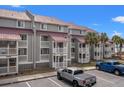 Multi-story condo building featuring covered balconies and ample parking space at 76 Mariners Cay Dr, Folly Beach, SC 29439