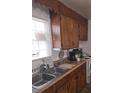 Wood cabinets line the kitchen with a double sink and view from the window above at 824 Orangeburg Rd, Summerville, SC 29483