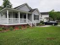 Charming home with a covered porch, a well-maintained lawn, and a paved driveway at 8309 Berringer Bluff, North Charleston, SC 29418