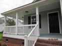 Inviting covered front porch with white railing, showcasing the home's exterior details and curb appeal at 8309 Berringer Bluff, North Charleston, SC 29418