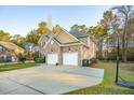 Wide driveway leading to a brick house, featuring a two-car garage and ample parking at 8716 Dover Creek St, North Charleston, SC 29420