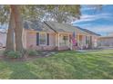 Beautiful brick home featuring a cozy porch with a swing and a lush green lawn at 886 Piccadilly Cir, Charleston, SC 29412