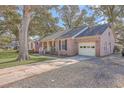Brick home boasting an attached garage, inviting porch, and a spacious driveway at 886 Piccadilly Cir, Charleston, SC 29412