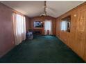 Living room featuring carpeted floors, wood paneled walls, a ceiling fan and a fireplace at 958 Adrian Ln, Moncks Corner, SC 29461