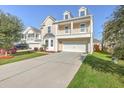 Attractive two-story home with a covered porch and a long concrete driveway and lawn at 9988 Winged Elm St, Ladson, SC 29456
