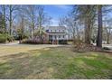 Landscaped lawn and mature trees surround this charming two-story home with a brick accent and a welcoming front porch at 100 Lakeview Dr, Summerville, SC 29485