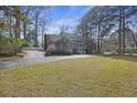 Home featuring a brick accent, blue shutters, a welcoming front porch, and mature landscaping at 100 Lakeview Dr, Summerville, SC 29485