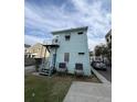 Rear view of a light blue two-story home with stairs leading to a second story door at 101 Queen St, Charleston, SC 29401