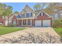 Inviting two-story home with brick accents, a spacious driveway, and a well-maintained front lawn at 103 Sago Palm Ct, Summerville, SC 29483