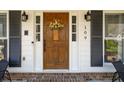 Inviting front entrance featuring a wood door, stylish lanterns, and decorative floral arrangement at 109 Buckingham Ave, Summerville, SC 29485