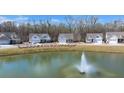 Scenic aerial view of houses surrounding a pond with a fountain, showcasing a peaceful residential community at 1174 Old Field Dr, Summerville, SC 29483