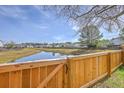 Scenic backyard view with a wooden fence overlooking a tranquil pond at 118 Lamplighter Ln, Summerville, SC 29486