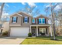 Inviting two-story home with a two-car garage, classic black shutters, and a cozy covered front porch at 1309 Belgian Draft Dr, Mount Pleasant, SC 29466