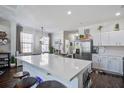 Bright kitchen features white cabinets, stainless steel appliances, a large island with barstool seating and modern light fixture at 156 Woodward Rd, Goose Creek, SC 29445