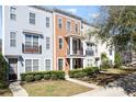 Charming multi-story townhome showcasing a front porch and balcony, with neat landscaping and vibrant curb appeal at 1587 Bluewater Way, Charleston, SC 29414